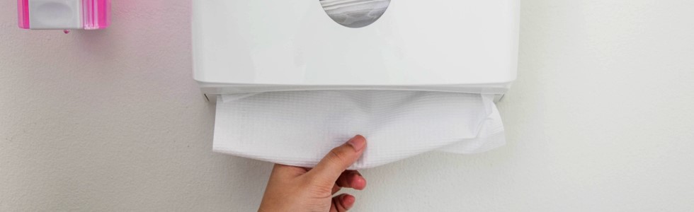Eine Person greift nach Handtuchpapier