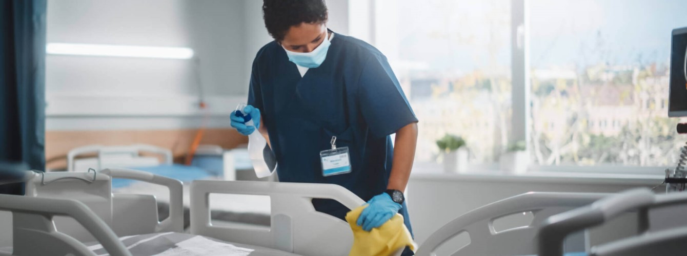 Eine Krankenschwester reinigt ein Krankenbett zur Vermeidung von Krankenhauskeimen