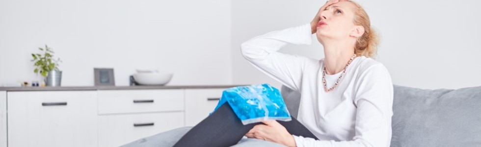 Eine Frau nutzt Kalt Warm Kompressen, um ihre Knieschmerzen zu lindern