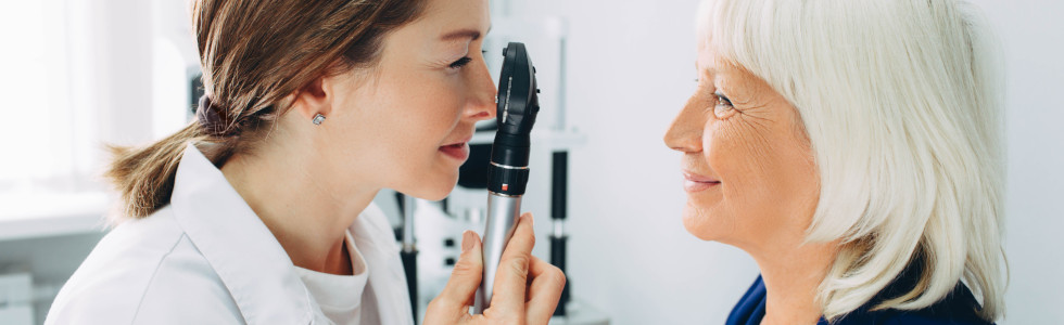 Augenärztin untersucht Auge einer Patientin mit dem Ophthalmoskop — jetzt Ophthalmoskop kaufen!