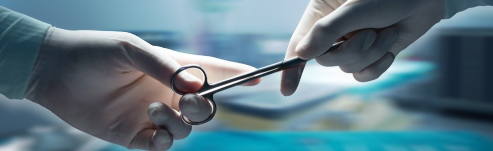 Ein Chirurg überreicht einem anderen Arzt einen Nadelhalter