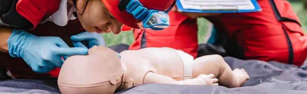 Feuerwehrfrau trainiert mit Rettungspuppe eines Babys