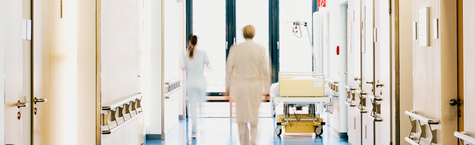 Ärzte laufen durch einen Krankenhausgang – Sicherheitsschilder kaufen hilft, die Orientierung zu bewahren