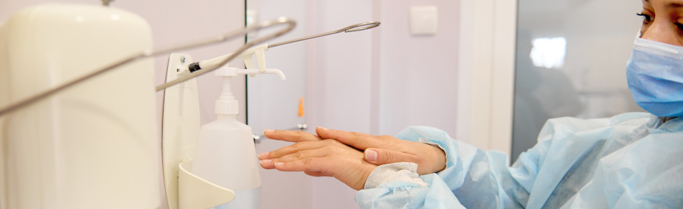 Eine Frau nutzt einen Seifenspender für die Arztpraxis