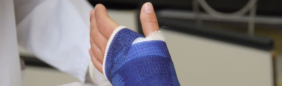 Arzt versorgt gebrochenen Arm mit Gipsverband aus dem Verbandsmaterial Sortiment
