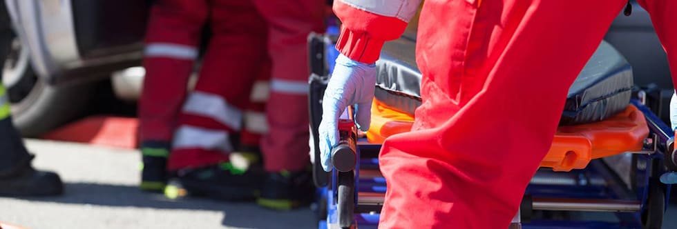 Notfallkräfte in leuchtendem Rot im Einsatz – eine Notfalltasche gefüllt nach Norm in Signalfarben bleibt sichtbar
