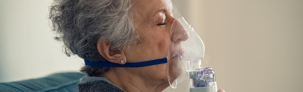 Eine ältere Frau benutzt eine Sauerstoffmaske, die man bei SANISMART als Sauerstoffzubehör kaufen kann