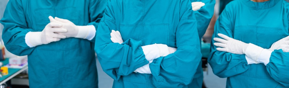 Ärzteteam im Operationssaal trägt OP-Handschuhe