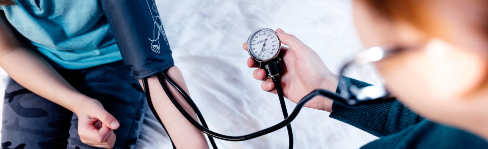 Ein Arzt nutzt ein Blutdruckmessgerät während der allgemeinen Diagnostik