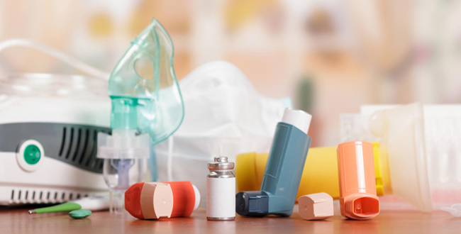 Auf einem Tisch stehen ein Inhaliergerät, Asthmaspay und weitere Inhalatoren