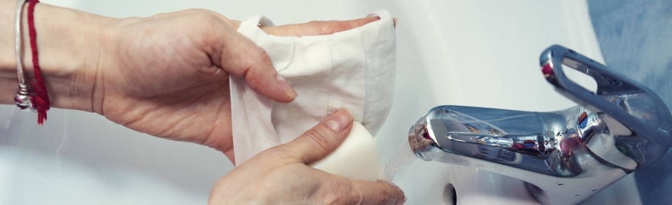 Eine Frau befeuchtet einen Einmal Waschhandschuh