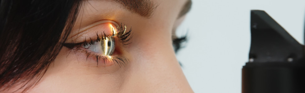 Licht scheint auf das Auge einer Frau bei einer ophthalmologischen Untersuchung — jetzt Ophthalmoskop kaufen!