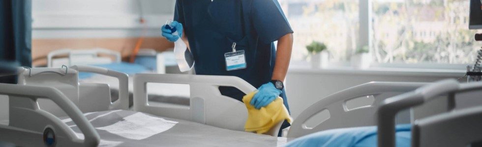 Ein Arzt reinigt ein Bett mit Desinfektionsmittel