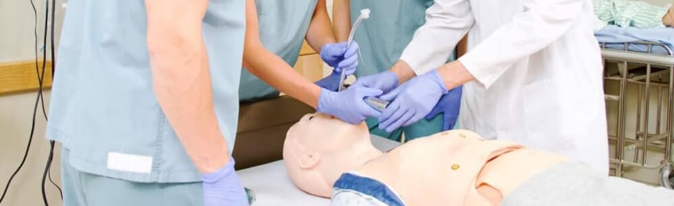 Arzt erklärt Studenten die Intubation an einer medizinischen Übungspuppe