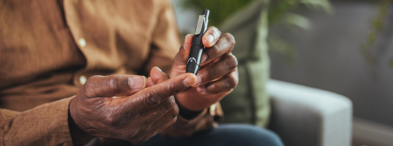 Ein Mann misst sein Insulin mit einem Pen am Finger